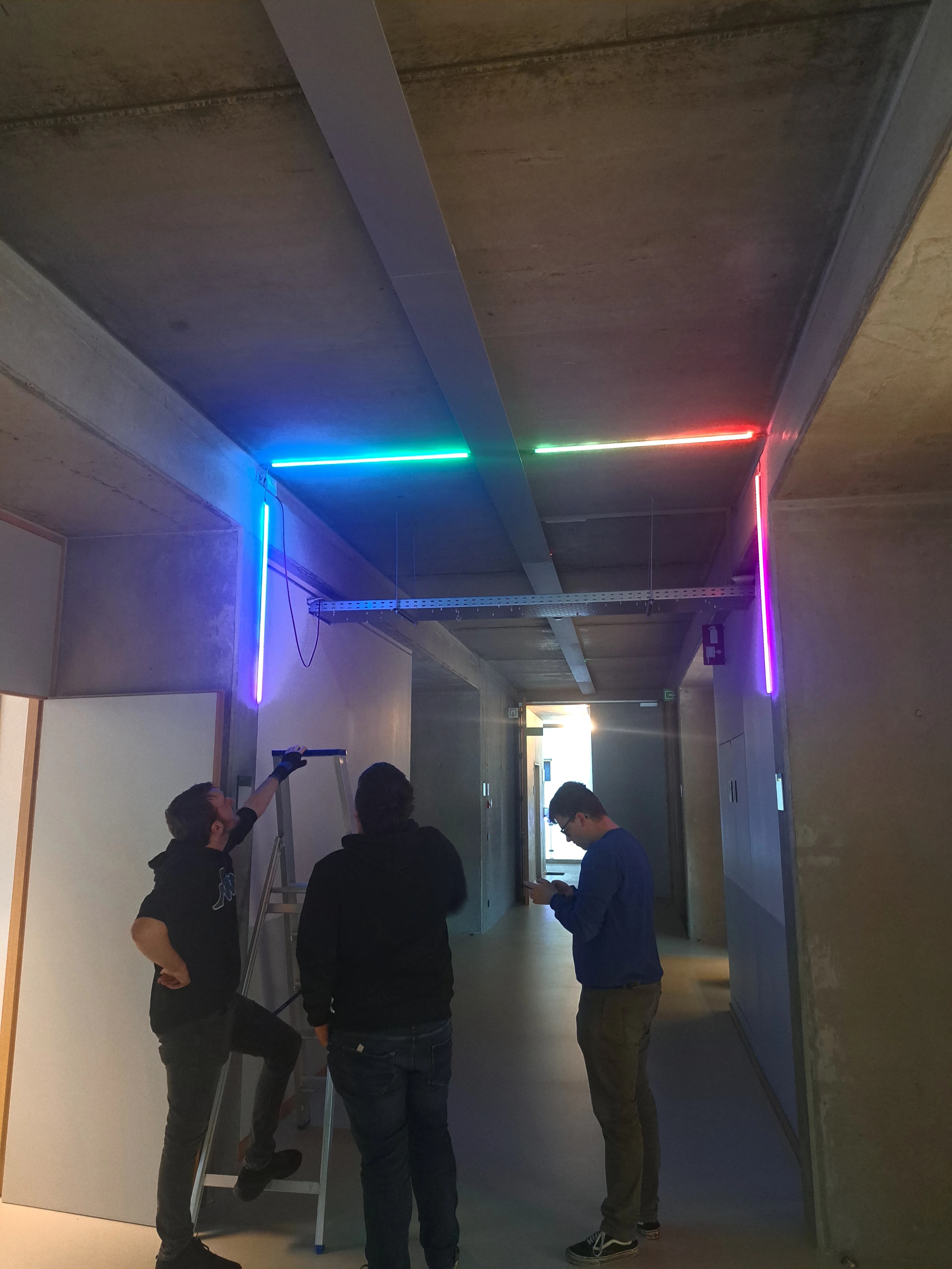 Development team working on interactive corridor project - hardware installation